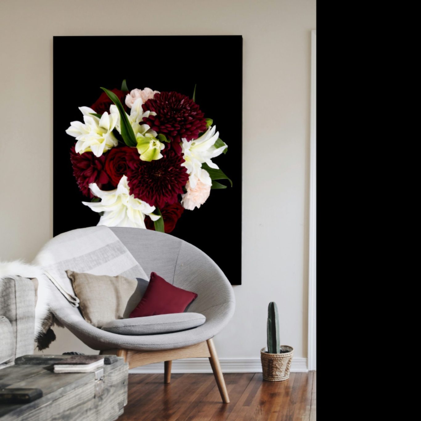 Art & Eden floral artwork: bold bouquet of deep red, white, and blush blooms on black background, displayed as elegant wall art in a room.