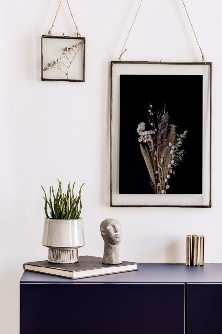 Stylish home decor featuring bespoke floral artwork, preserving memories and delicate dried flowers on black background.